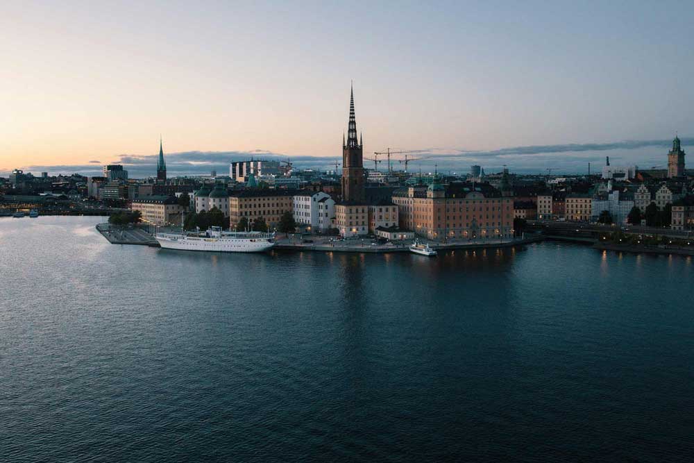 Vy över Stockholm från vattnet i skymning.